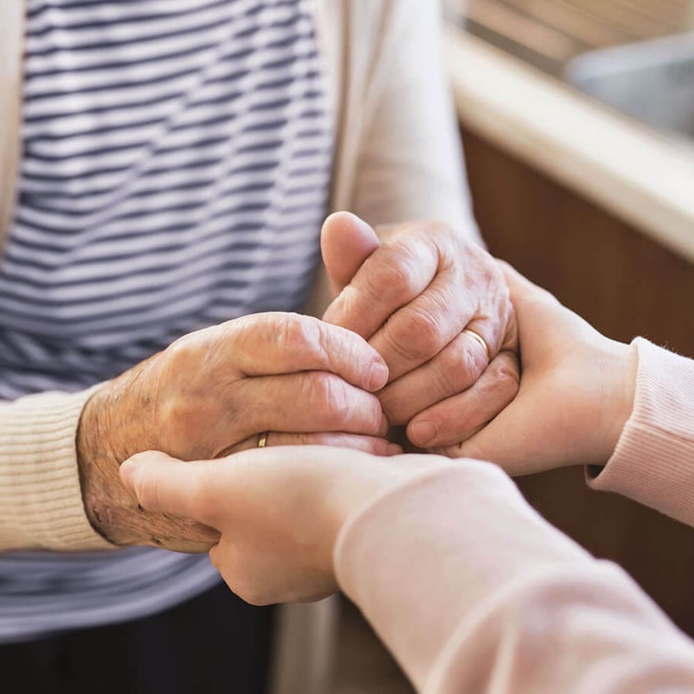 Resident holding hands with a caretaker at Anthology Senior Living in Chicago, Illinois