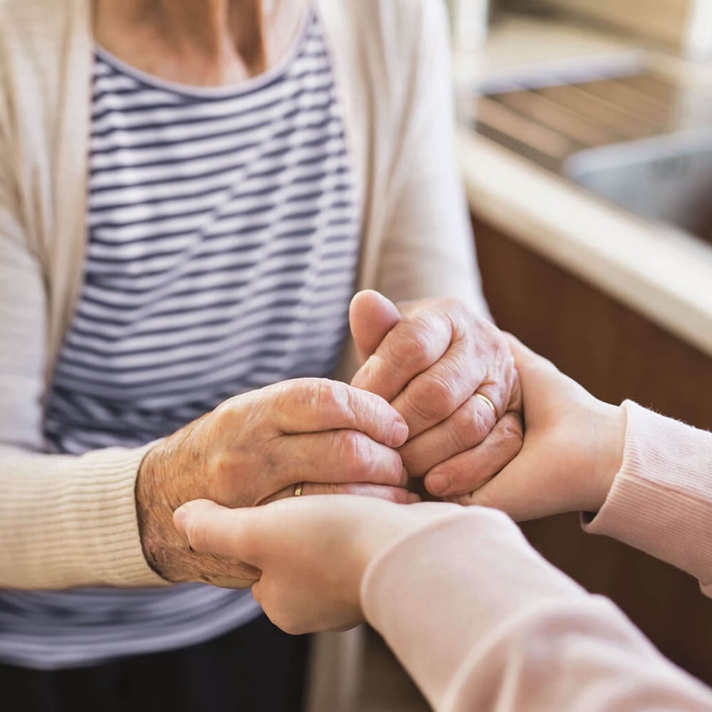 Resident and caretaker holding hands at Anthology Senior Living in Chicago, Illinois