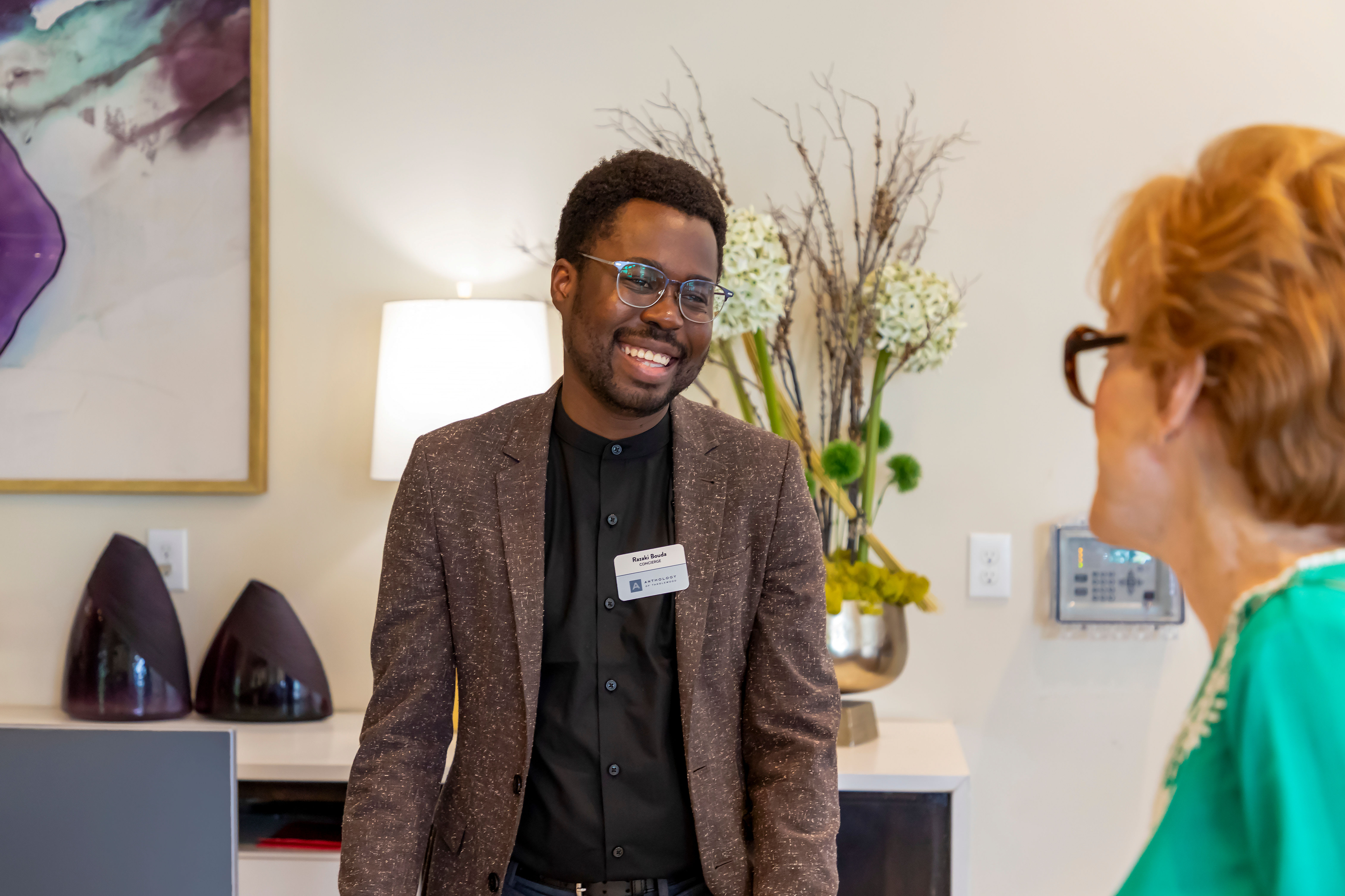 Well dressed person laughing in a brightly lit room