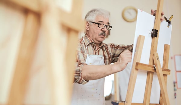 Elderly man working on a painting at Anthology Senior Living in Chicago, Illinois
